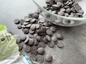 Recept na domácí Reeses - zdravé čokoládové košíčky s arašídovým máslem - nejdříve roztopíme čokoládové pecičky ve vodní lázni...